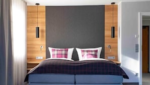 Ein modernes Schlafzimmer mit einem Bett, zwei Nachttischen, einer Holzvertäfelung und einem grauen Kopfteil.