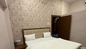 Een slaapkamer met een bed, een houten hoofdeinde, een wand met een marmerpatroon, een houten deur en een betegelde vloer.