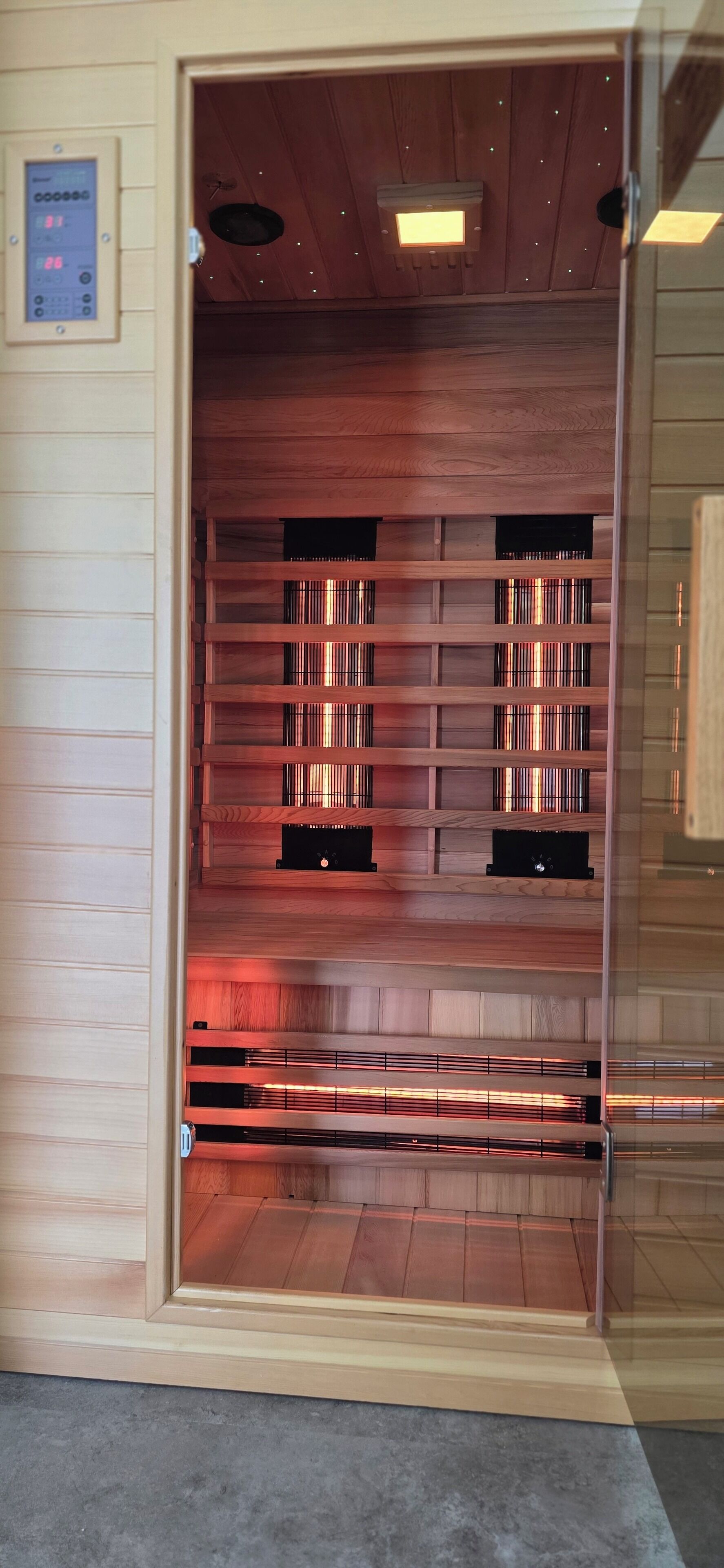 Una habitación con una estantería de madera, un termostato y una puerta.