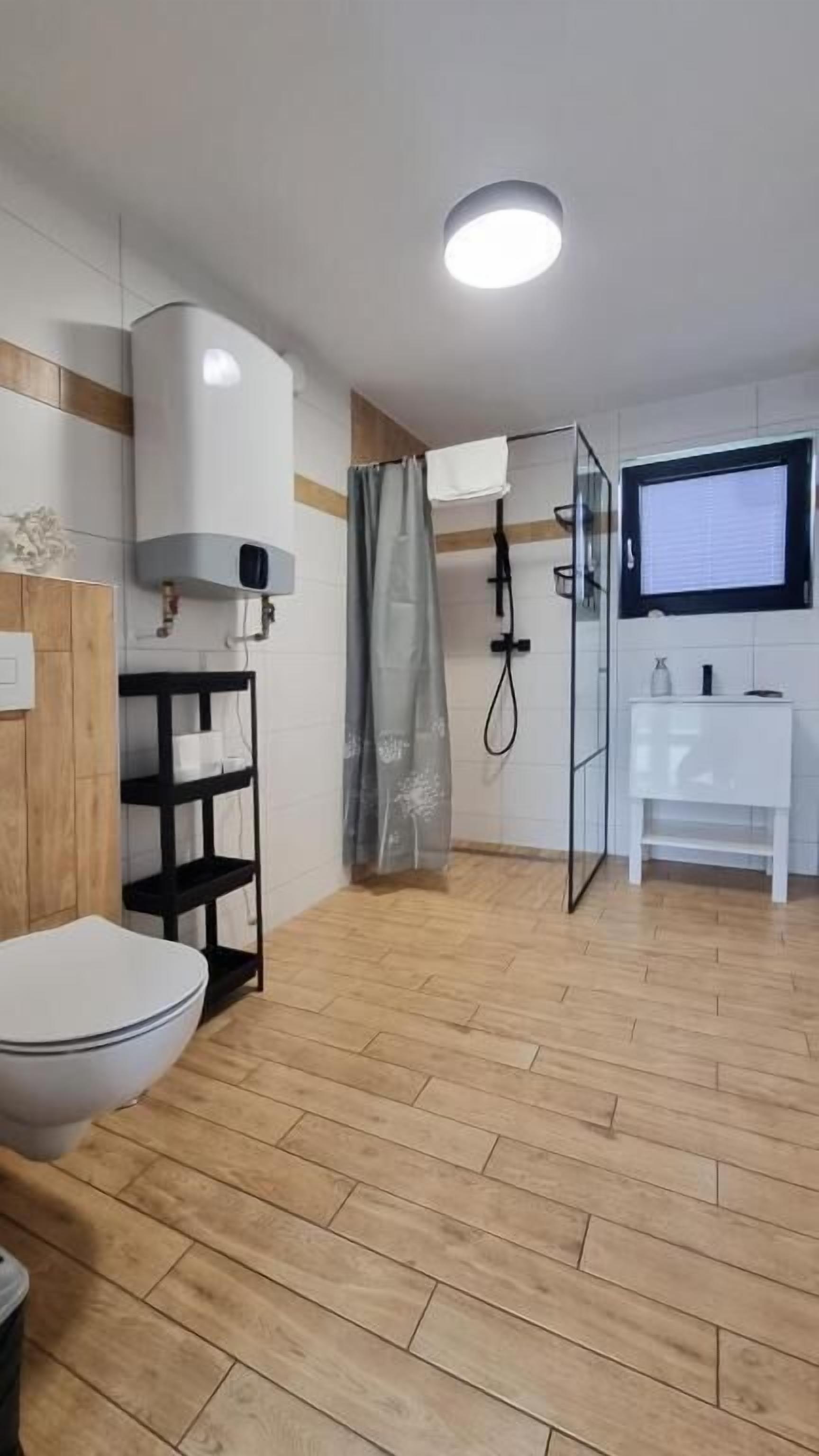 A modern bathroom with a toilet, shower, and sink.