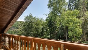 A wooden balcony with a view of a forested area. - Apartment 'Wohung Zum Ausblick' with Mountain View, Balcony and Wi-Fi (Plettenberg)
