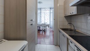 A compact kitchen with a built-in oven, a sink, and a stove. - A Casa di Silvia by Wonderful Italy (Catania)