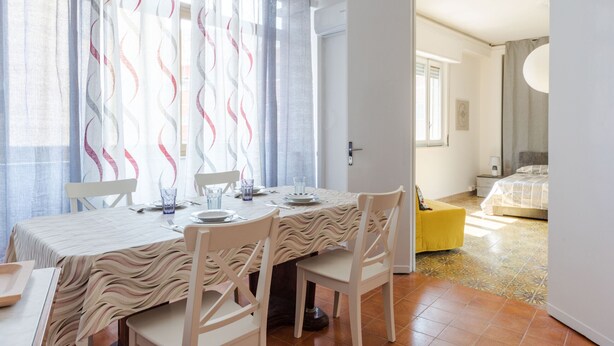 A dining area with a table set for four, chairs, and a patterned tablecloth. - A Casa di Silvia by Wonderful Italy (Catania)