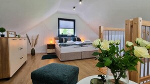 A cozy bedroom with a bed, bedside tables, a dresser, and a window. - ZATOR Domki INTERSTYL (Zator)