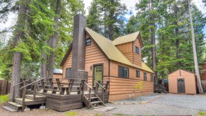 A rustic log cabin with a chimney, wooden stairs, and a small adjacent shed. - Moose Manor With BBQ - Near Tahoe Hiking! (Tahoma)