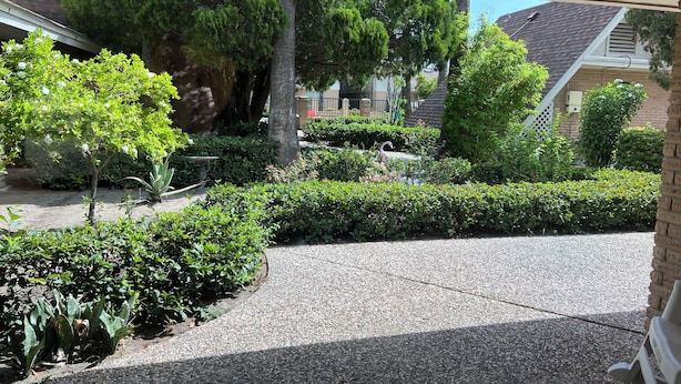 A well-maintained garden with various plants and a gravel pathway. - Cute, Comfy & Walkable 2/2 Condo Central McAllen (McAllen)