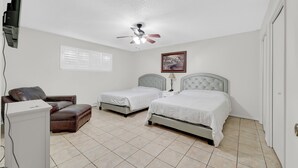 A bedroom with two beds, a desk, a chair, a ceiling fan, and a window with blinds. - Cute, Comfy & Walkable 2/2 Condo Central McAllen (McAllen)