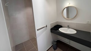 Un baño moderno con ducha, lavabo y espejo.