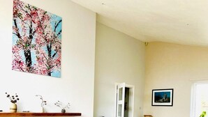 A living room with a fireplace, a sofa, a coffee table, and a painting on the wall. - 4-bed Seaside Dream House - Sleeps 8 & Parking (Dundee)