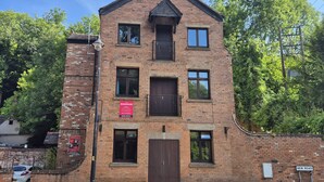 Un bâtiment à deux étages, construit en briques, avec une enseigne indiquant qu’il s’agit d’une boulangerie.