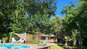 A wooden deck with a swimming pool, surrounded by lush greenery and trees. - Evasion Nature Home & Glamping (Grayan-et-l'Hôpital)