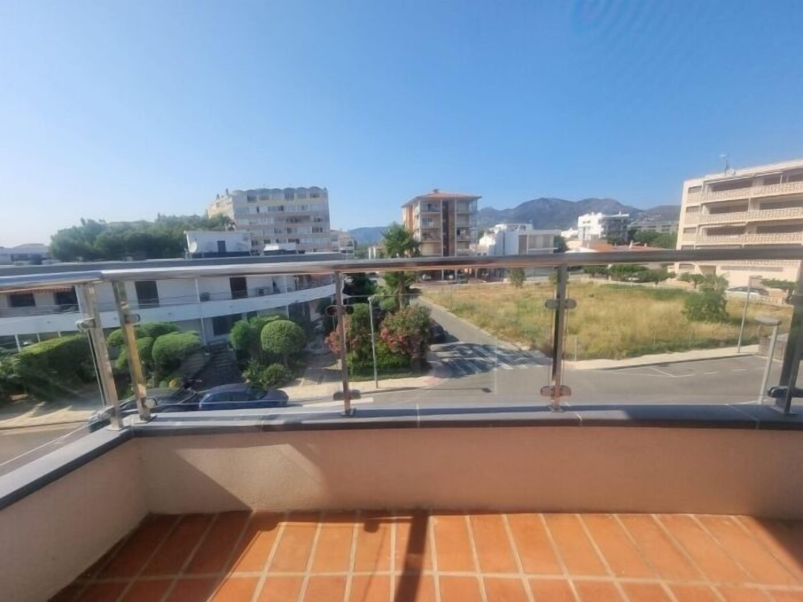 Un balcon donnant sur un quartier résidentiel, avec vue sur des immeubles et une rue.