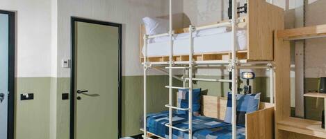 A bunk bed with a wooden frame, a bedside table, a lamp, and a television mounted on the wall.