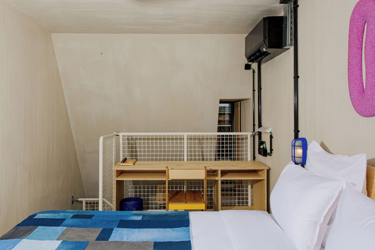 A bedroom with a bunk bed, a desk, and a television.