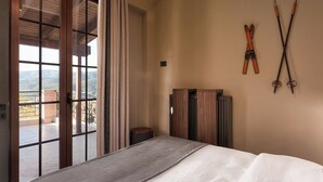Een slaapkamer met een groot raam, een bed en ski’s bevestigd aan de muur.