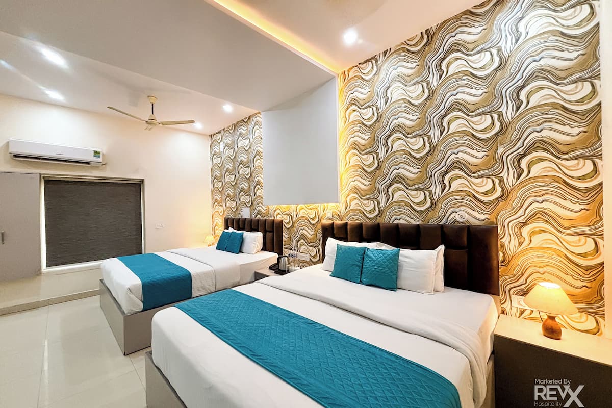 A hotel room with two beds, a large patterned wall, a ceiling fan, and an air conditioning unit.