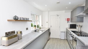 Une cuisine moderne dotée d’un îlot central, d’appareils électroménagers intégrés et d’un design épuré et minimaliste.