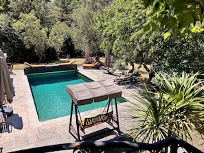 A rectangular pool with a tiled deck, surrounded by lounge chairs and umbrellas. - Ekin Ô reV (Montauroux)