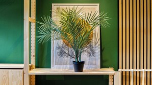 A framed artwork of a tree with a potted plant in front of it.