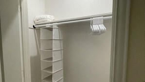 A walk-in closet with a white shelving unit, a hanging rod, and a folded towel on the rod. - Texas Music City is a 5-minute walk from this 2 bedroom apartment (Lindale)