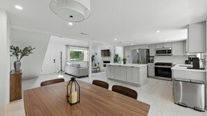 A modern kitchen with white cabinets, stainless steel appliances, and a central island. - Modern 3BR Home w/ Backyard in South Austin (Austin)