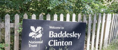 A welcome sign for Baddesley Clinton with the National Trust logo.