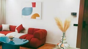 A modern living room with a sectional sofa, a blue coffee table, and a decorative vase.