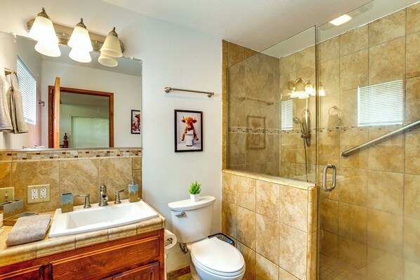 Une salle de bain avec un lavabo, des toilettes et une douche.
