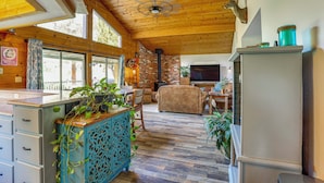 A cozy cabin interior with a wooden ceiling, a TV, a sofa, and a dining area. - Scenic Riverfront Escape w/ Sauna in Junction City (Junction City)