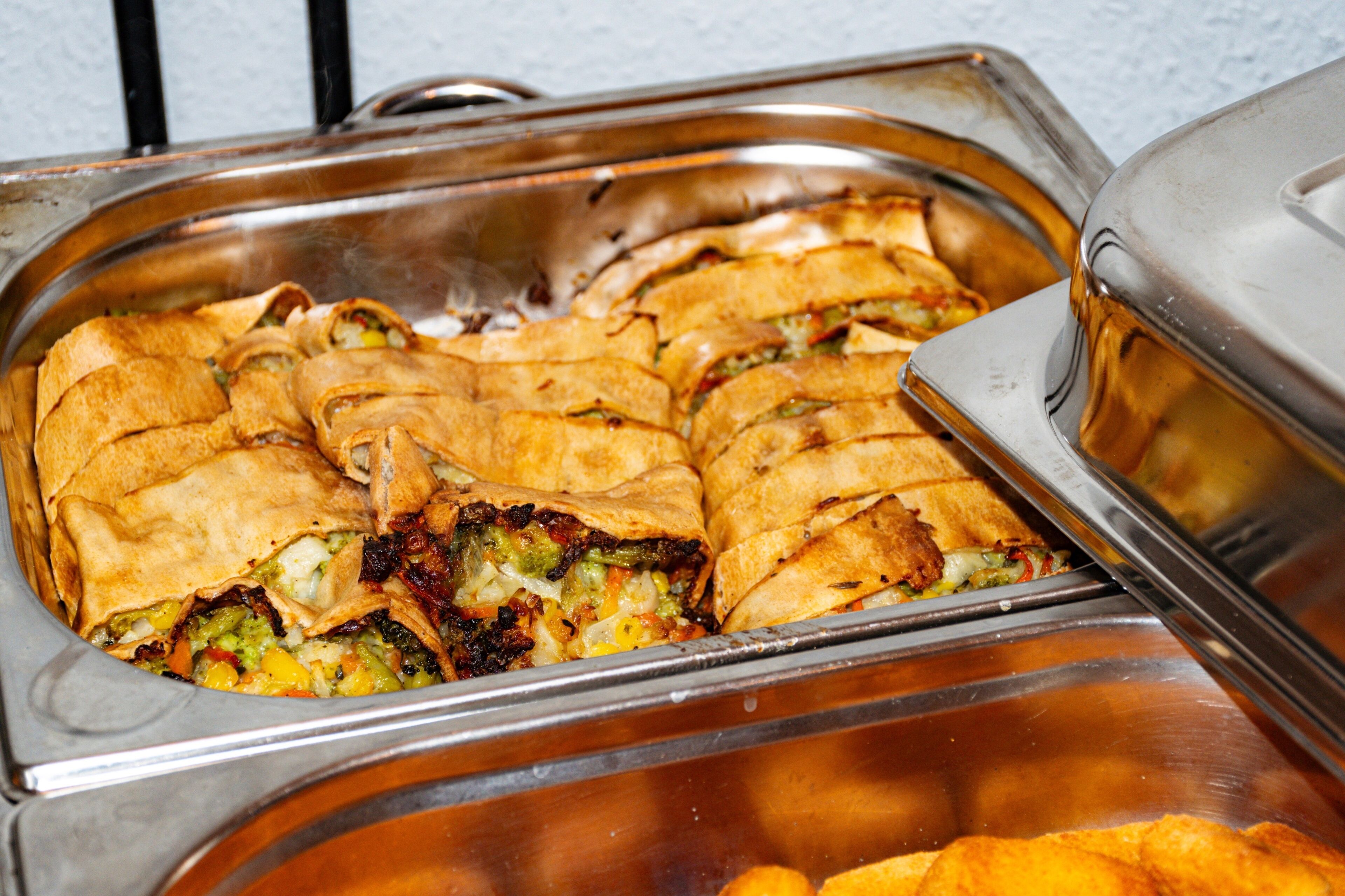 Un buffet proposant une variété de plats, notamment un espace dédié aux produits de boulangerie et un autre proposant un type de nourriture différent.