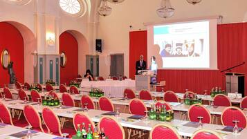 A conference room with tables, chairs, and a presentation screen.