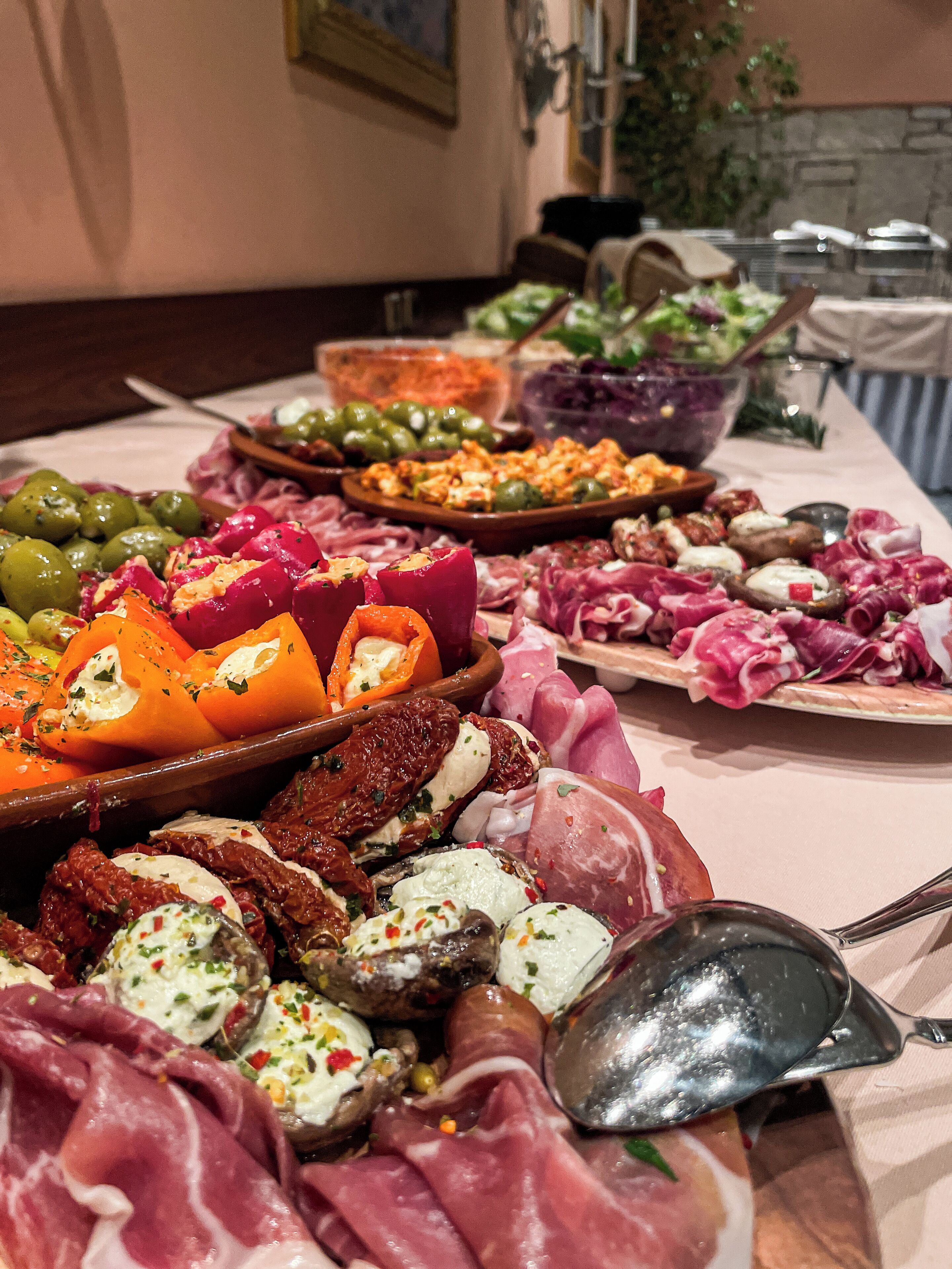 A table with various food items including olives, cured meats, and cheese.