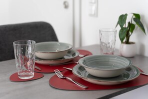 A dining table set with plates, bowls, and a glass.