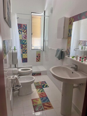 Chuveiro, bidê, toalhas de banho, sabonete