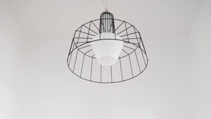 A kitchen with a modern pendant light, a coffee maker, a kettle, and a scale.