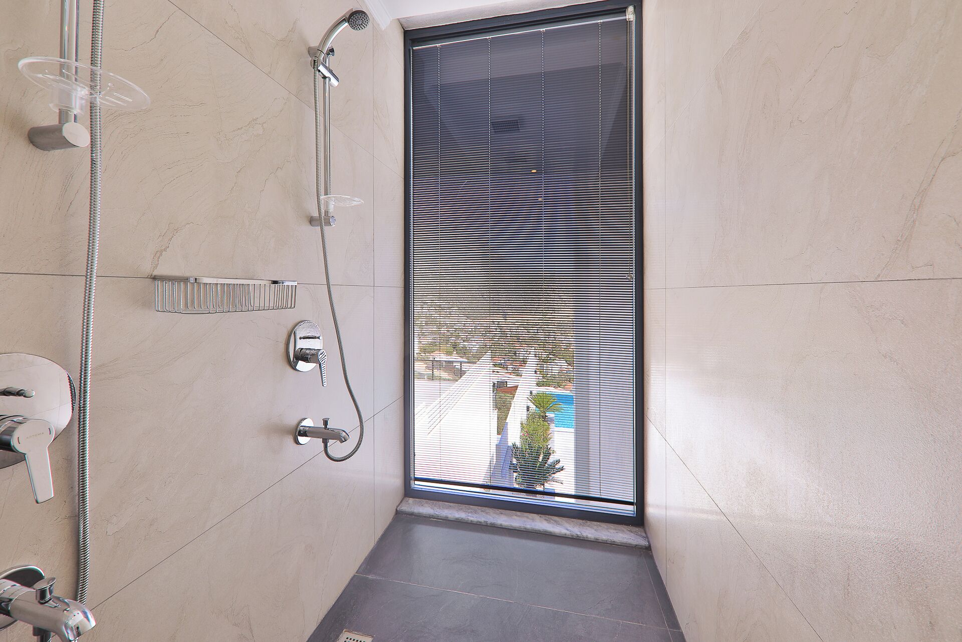 A modern bathroom with a shower, toilet, and sink.