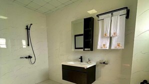 A modern bathroom with a freestanding sink, a toilet, and a shower with a handheld showerhead. - 520 HÔTEL et RESIDENCE (Abidjan)