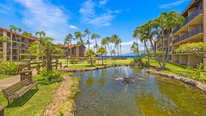 A resort with a pool, palm trees, and a view of the ocean. - Papakea G101 1bed/1bath New Remodel 1 Bedroom Condo (Lahaina)