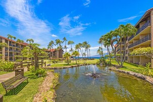 Un resort con piscina, palmeras y vista al océano.