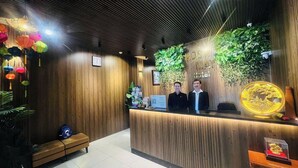 A reception area with wooden paneling, a reception desk, and a large decorative globe. - Rosa May Hotel (Ho Chi Minh City)