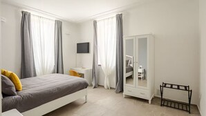 A bedroom with a bed, a desk, a wardrobe, and a TV. - Design Apartment in center(Piazza del Popolo)- Parking (Rome)