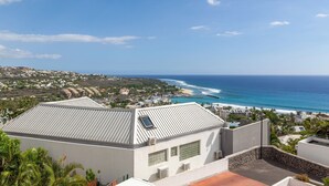A coastal residential area with a view of the ocean and a clear sky.
