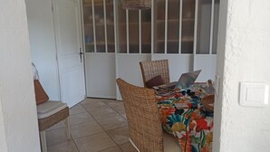 Ein Zimmer mit Essbereich, ausgestattet mit Korbstühlen und einem Tisch mit bunten Tischdecken.