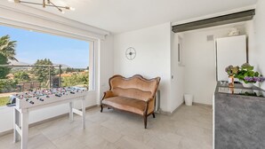 Una stanza con un divano, un tavolo da calcio, una sveglia e vista sull'esterno.