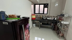 Une cuisine équipée d’un réfrigérateur, d’une cuisinière et de divers ustensiles de cuisine.
