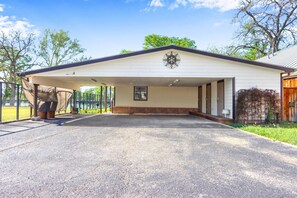 A covered parking area with a building in the background. - Amazing Lakefront Escape - A Stunner For Sleeps 14 (New Braunfels)