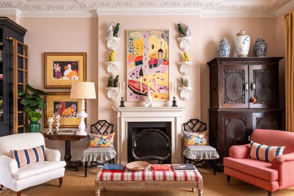 A living room with a fireplace, a bookshelf, a coffee table, and a sofa.