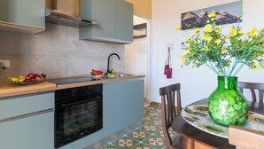 A kitchen with a built-in oven, a sink, and a dining area with a table and chairs.