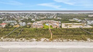 A beachfront hotel with a central courtyard, multiple balconies, and a view of the ocean. - Oceanfront Creston House Condo (Unit 5C) (St. Augustine)