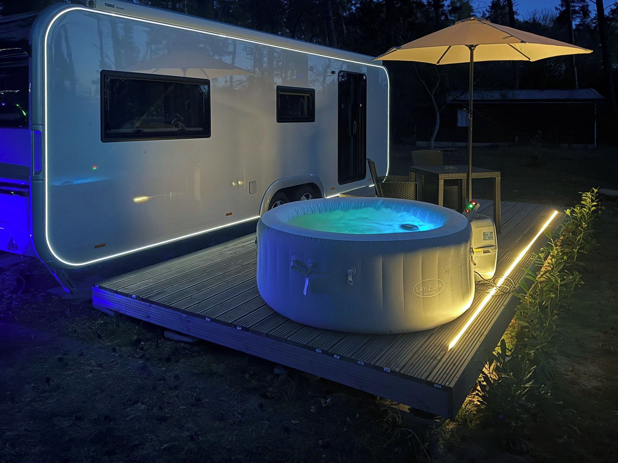 A recreational vehicle with a hot tub and an umbrella.